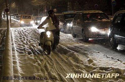 1月6日，在荷兰阿姆斯特丹，一名行人推车走在雪地上。